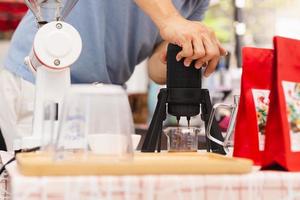 Barista making espresso coffee using aeropress in cafe. photo