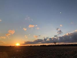 puesta de sol sobre el campo de la granja foto