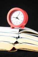 Red clock on books photo