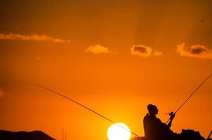 Fishing pole over the sunset photo