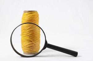 Spool of sewing thread with magnifying glass photo