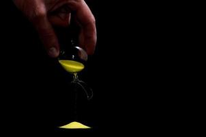 Broken hourglass on black background photo