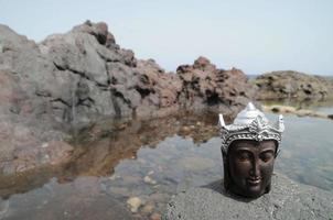 Buda en miniatura sobre rocas foto