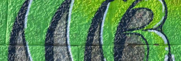 Fragment of graffiti drawings. The old wall decorated with paint stains in the style of street art culture. Colored background texture in green tones photo
