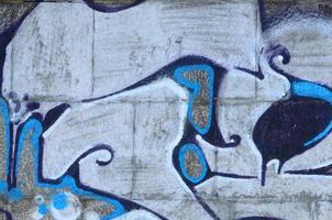 Fragment of graffiti drawings. The old wall decorated with paint stains in the style of street art culture. Colored background texture in warm tones photo