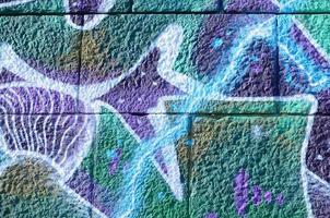 Fragment of graffiti drawings. The old wall decorated with paint stains in the style of street art culture. Colored background texture in cold tones photo