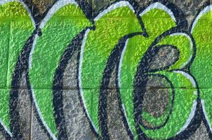 Fragment of graffiti drawings. The old wall decorated with paint stains in the style of street art culture. Colored background texture in green tones photo