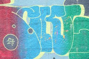 Fragment of graffiti drawings. The old wall decorated with paint stains in the style of street art culture. Colored background texture in cold tones photo