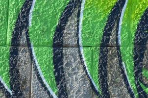 Fragment of graffiti drawings. The old wall decorated with paint stains in the style of street art culture. Colored background texture in green tones photo