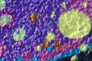 Fragment of graffiti drawings. The old wall decorated with paint stains in the style of street art culture. Multicolored background texture photo
