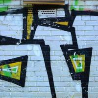 Fragment of graffiti drawings. The old wall decorated with paint stains in the style of street art culture. Colored background texture photo