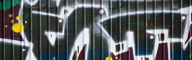 Fragment of graffiti drawings. The old wall decorated with paint stains in the style of street art culture. Colored background texture in green tones photo