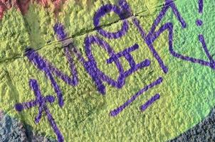 fragmento de dibujos de graffiti. la antigua muralla decorada con manchas de pintura al estilo de la cultura del arte callejero. textura de fondo coloreada en tonos cálidos foto