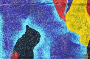 Fragment of graffiti drawings. The old wall decorated with paint stains in the style of street art culture. Multicolored background texture photo