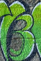 Fragment of graffiti drawings. The old wall decorated with paint stains in the style of street art culture. Colored background texture in green tones photo