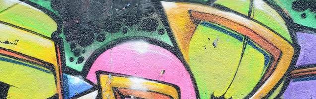 Fragment of graffiti drawings. The old wall decorated with paint stains in the style of street art culture. Multicolored background texture photo