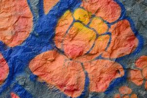 Fragment of graffiti drawings. The old wall decorated with paint stains in the style of street art culture. Orange flower photo