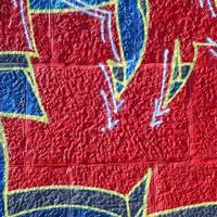 fragmento de dibujos de graffiti. la antigua muralla decorada con manchas de pintura al estilo de la cultura del arte callejero. textura de fondo coloreada en tonos cálidos foto