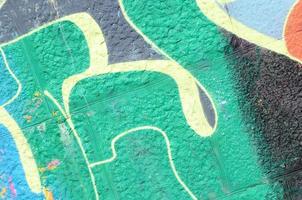 Fragment of graffiti drawings. The old wall decorated with paint stains in the style of street art culture. Colored background texture in green tones photo