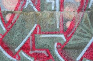 fragmento de dibujos de graffiti. la antigua muralla decorada con manchas de pintura al estilo de la cultura del arte callejero. textura de fondo coloreada en tonos cálidos foto