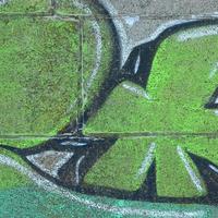 Fragment of graffiti drawings. The old wall decorated with paint stains in the style of street art culture. Colored background texture in green tones photo