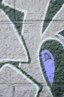 Fragment of graffiti drawings. The old wall decorated with paint stains in the style of street art culture. Colored background texture in purple tones photo