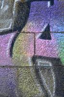 Fragment of graffiti drawings. The old wall decorated with paint stains in the style of street art culture. Multicolored background texture photo