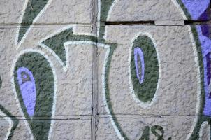 Fragment of graffiti drawings. The old wall decorated with paint stains in the style of street art culture. Colored background texture in purple tones photo