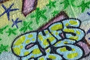 Fragment of graffiti drawings. The old wall decorated with paint stains in the style of street art culture. Colored background texture in green tones photo