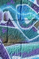 Fragment of graffiti drawings. The old wall decorated with paint stains in the style of street art culture. Colored background texture in cold tones photo