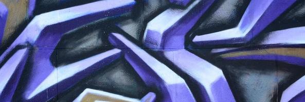 Fragment of graffiti drawings. The old wall decorated with paint stains in the style of street art culture. Colored background texture in purple tones photo