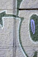 Fragment of graffiti drawings. The old wall decorated with paint stains in the style of street art culture. Colored background texture in purple tones photo