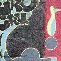 Fragment of graffiti drawings. The old wall decorated with paint stains in the style of street art culture. Multicolored background texture photo