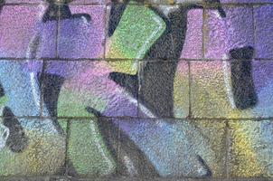 Fragment of graffiti drawings. The old wall decorated with paint stains in the style of street art culture. Multicolored background texture photo