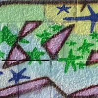 Fragment of graffiti drawings. The old wall decorated with paint stains in the style of street art culture. Colored background texture in green tones photo