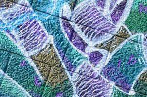 Fragment of graffiti drawings. The old wall decorated with paint stains in the style of street art culture. Colored background texture in cold tones photo