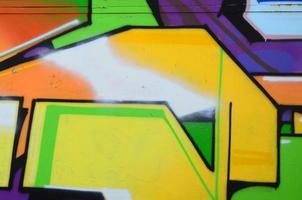 Fragment of graffiti drawings. The old wall decorated with paint stains in the style of street art culture. Multicolored background texture photo