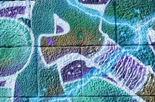 Fragment of graffiti drawings. The old wall decorated with paint stains in the style of street art culture. Colored background texture in cold tones photo