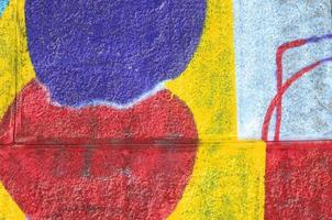Fragment of graffiti drawings. The old wall decorated with paint stains in the style of street art culture. Multicolored background texture photo