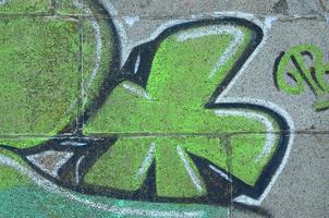 Fragment of graffiti drawings. The old wall decorated with paint stains in the style of street art culture. Colored background texture in green tones photo