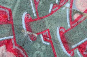 fragmento de dibujos de graffiti. la antigua muralla decorada con manchas de pintura al estilo de la cultura del arte callejero. textura de fondo coloreada en tonos cálidos foto