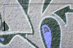 Fragment of graffiti drawings. The old wall decorated with paint stains in the style of street art culture. Colored background texture in purple tones photo