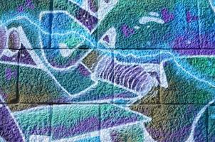 Fragment of graffiti drawings. The old wall decorated with paint stains in the style of street art culture. Colored background texture in cold tones photo