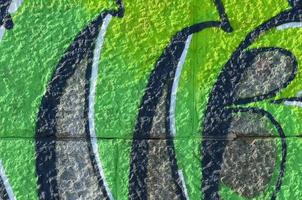Fragment of graffiti drawings. The old wall decorated with paint stains in the style of street art culture. Colored background texture in green tones photo