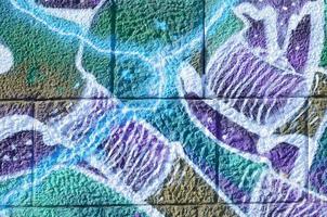 Fragment of graffiti drawings. The old wall decorated with paint stains in the style of street art culture. Colored background texture in cold tones photo