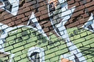 fragmento de dibujos de graffiti. la antigua muralla decorada con manchas de pintura al estilo de la cultura del arte callejero. textura de fondo coloreada en tonos cálidos foto