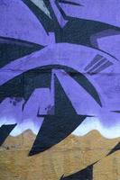 Fragment of graffiti drawings. The old wall decorated with paint stains in the style of street art culture. Colored background texture in purple tones photo