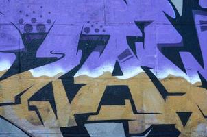 Fragment of graffiti drawings. The old wall decorated with paint stains in the style of street art culture. Colored background texture in purple tones photo