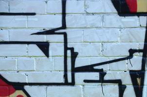 Fragment of graffiti drawings. The old wall decorated with paint stains in the style of street art culture. Colored background texture photo