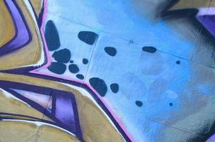 Fragment of graffiti drawings. The old wall decorated with paint stains in the style of street art culture. Colored background texture in purple tones photo